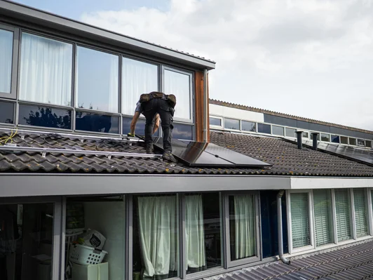 Dakdekker werkt aan de aansluiting van een dakkapel